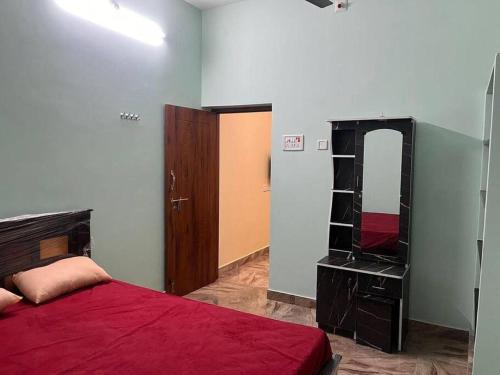 a bedroom with a red bed and a mirror at KR homestay in Tiruvannāmalai