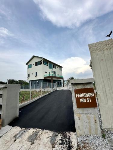a building on a road with a sign in front of it at Ferringhi Inn 51 in Batu Ferringhi
