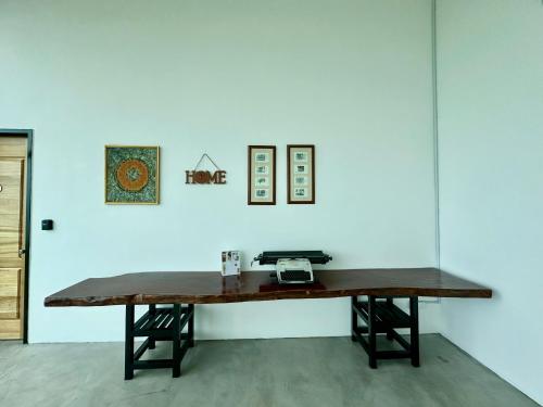 a wooden table in front of a white wall at Ferringhi Inn 51 in Batu Ferringhi