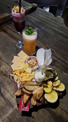 a tray of crackers and snacks on a table with a drink at Cabaña en Rio Puelo in Puelo