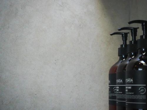 two bottles of liquid sitting next to a wall at Suku Lifestyle Hotel & Villas in Selong Belanak