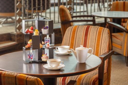 a table with cups of coffee and cakes on it at ANA Crowne Plaza Fukuoka by IHG in Fukuoka