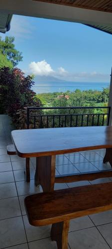 a bench on a balcony with a view of the ocean at Kimmy Tahiti House in Punaauia