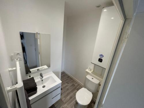 une salle de bain blanche avec des toilettes et un lavabo dans l'établissement Appartement T2 N3, Proche Naval Group et Centre Ville, à Cherbourg en Cotentin