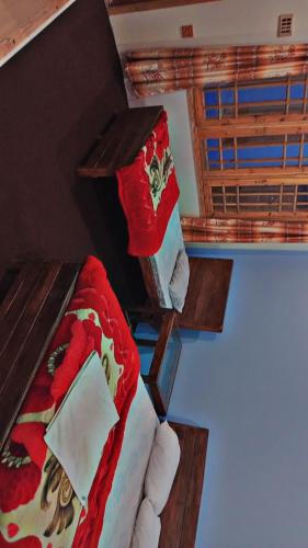 a room with two beds and a window at Rakaposhi Amin Hotel & Restaurant Pissan Hunza Nagar Gilgit Baltistan in Gilgit