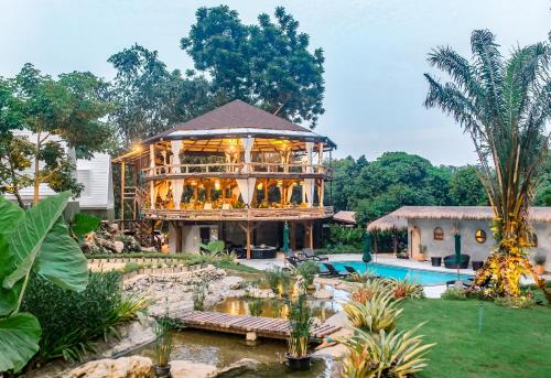 a large building with a pool in a yard at Voasis Valley Krabi - Natural Resort - Adults Only in Ban Nong Kok (1)