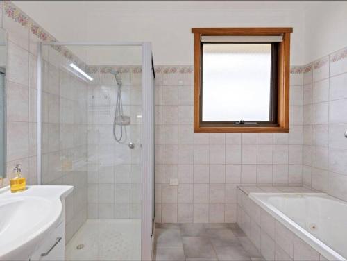 Un baño con bañera, lavabo y ducha. en Saltwater Views, en Cowes