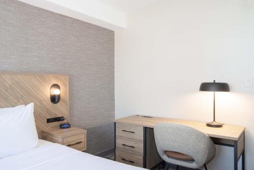 a bedroom with a desk and a bed and a chair at Sandman Hotel & Suites Regina in Regina