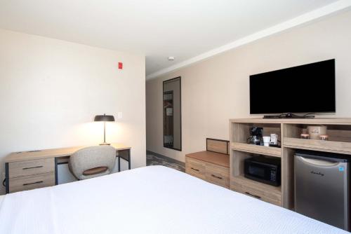 a bedroom with a bed and a flat screen tv at Sandman Hotel & Suites Regina in Regina