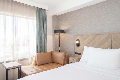 a hotel room with a bed and a chair at Sandman Hotel & Suites Regina in Regina