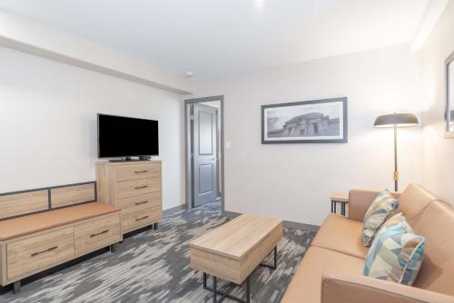 a living room with a couch and a tv at Sandman Hotel & Suites Regina in Regina