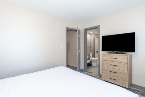 a bedroom with a bed and a flat screen tv at Sandman Hotel & Suites Regina in Regina