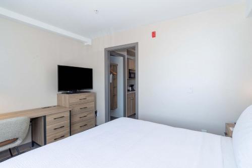 a bedroom with a bed and a flat screen tv at Sandman Hotel & Suites Regina in Regina