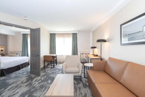 a hotel room with a couch and a bed at Sandman Hotel & Suites Regina in Regina