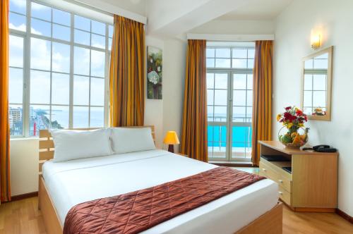 a bedroom with a large bed and windows at Global Towers Hotel & Apartments in Colombo
