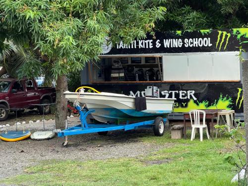 a boat on a trailer in front of a building at La maison près du Phare in Mahina