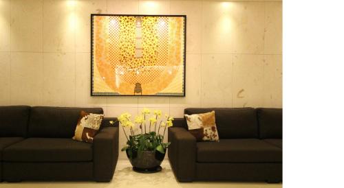 a living room with two couches and a painting at Hotel Migliore Seoul in Seoul