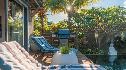 a patio with two chairs and a grill at Villa Sartelo in Tamarin