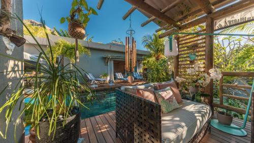 a patio with a couch and potted plants at Villa Sartelo in Tamarin