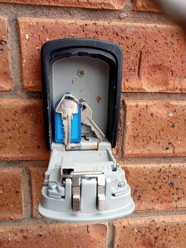 a light in a brick wall with a key in it at Blue Wren Cottage in Tumut
