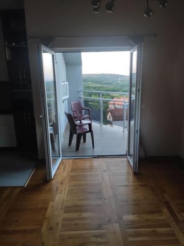 a room with a door open to a balcony with a chair at Apartman Lenka in Belgrade
