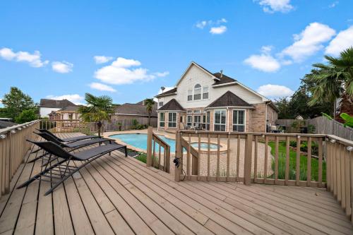 a wooden deck with a pool and a house at Lake Houston Getaway Pool Spa Lake Front in Humble