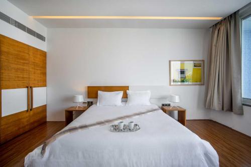 a bedroom with a large white bed with two lamps at Casa De Fiesta at Vasco Da Gama by StayVista in Dabolim