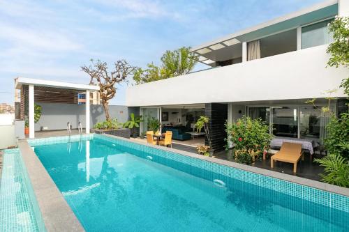 a swimming pool in front of a house at Casa De Fiesta at Vasco Da Gama by StayVista in Dabolim
