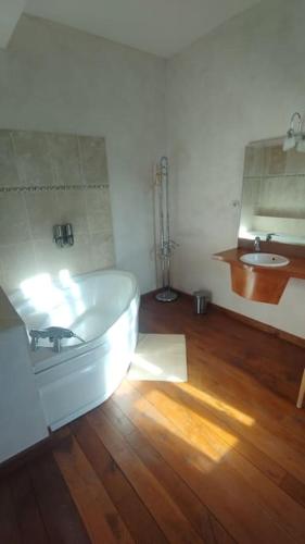 a bathroom with a white tub and a sink at Domaine du prieuré Saint Ellier in  Charcé-Saint-Ellier-sur-Aubance