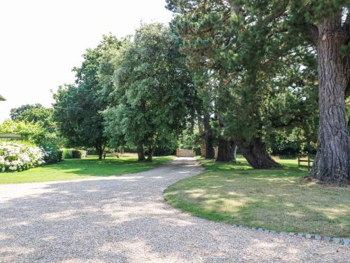 a gravel road in a park with trees and grass at Lymington Lodge in Lymington