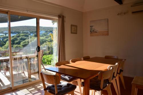 a dining room with a table and a large window at Ocean View Beach House, Margaret River in Gnarabup