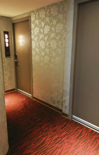 an empty hallway with a door and a red carpet at HopeCity MinSheng Hotel in Taipei