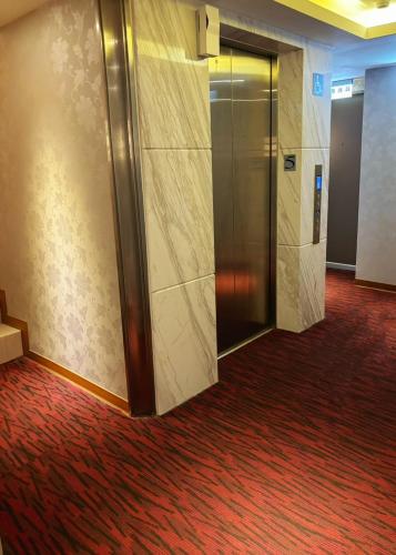 a hallway with a elevator in a building at HopeCity MinSheng Hotel in Taipei