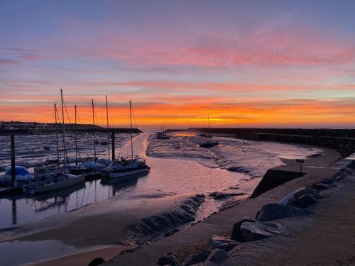 a group of boats docked in a marina at sunset at Appartement vue sur mer et le port in Jard-sur-Mer