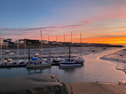a group of boats docked in a marina at sunset at Appartement vue sur mer et le port in Jard-sur-Mer