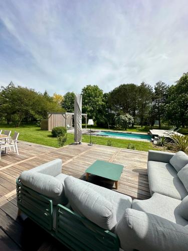 une terrasse avec un canapé, une table et une piscine dans l'établissement La salmoniere, à La Roche-Blanche