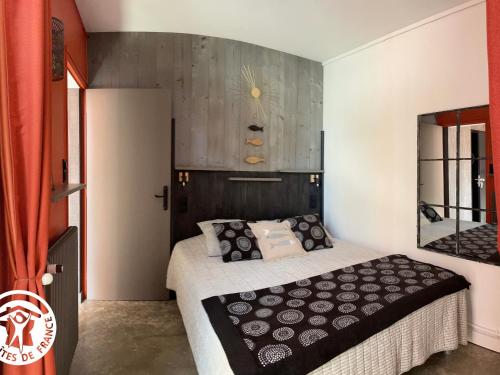 une chambre avec un lit et un miroir au mur dans l'établissement Gîte rénové proche plage, centre-ville et pistes cyclables avec terrasse privative - FR-1-426-560, à Les Sables-dʼOlonne