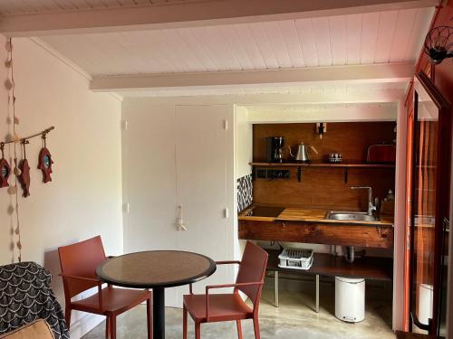 une cuisine avec une table et des chaises dans une pièce dans l'établissement Gîte rénové proche plage, centre-ville et pistes cyclables avec terrasse privative - FR-1-426-560, à Les Sables-dʼOlonne