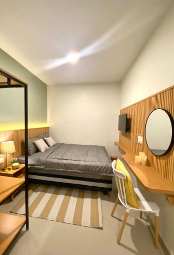 a bedroom with a bed and a desk and a mirror at Como Homestay Batam in Batam Center