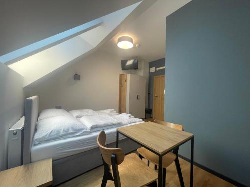 Un dormitorio con una cama y una mesa de madera. en Rent Apartment, en Wieliczka