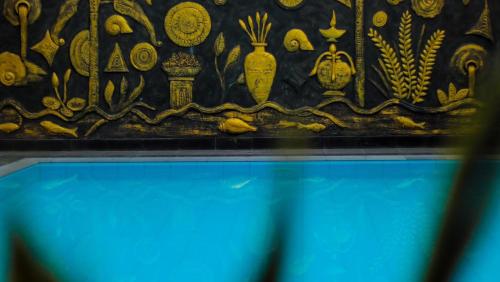 a wall with a bunch of gold items on it at Bivon Reach in Uswetakeiyawa