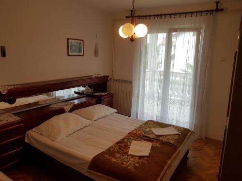 a bedroom with a large bed and a window at Milka Apartments in Njivice