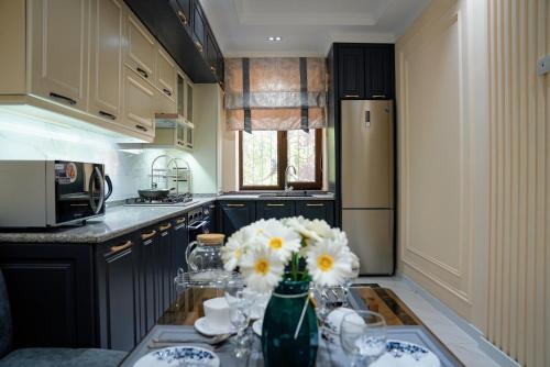 a kitchen with a vase of flowers on a counter at Learmara Apartment #2 in Samarkand