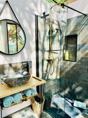 une salle de bain avec un lavabo et une douche en verre dans l'établissement Domaine la Madeleine - Hébergement insolite, à Aubagne