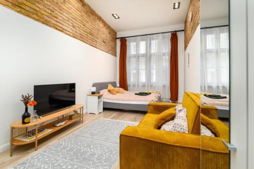 a living room with a yellow couch and a bed at Downtown apartment 2 minutes from Opera House in Budapest