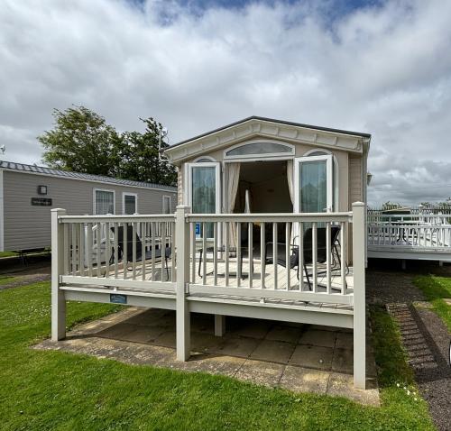a small house with a porch on a yard at Parkside 41 - Located on Butlins Skegness Caravan Village, WiFi - Meadow Lakes Caravan & Lodge Hire in Lincolnshire