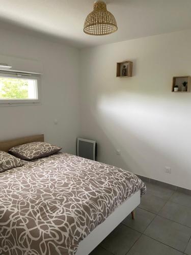 - une chambre avec un lit et une lampe pendant dans l'établissement T2 tout équipé à 300m de la plage, à Vias