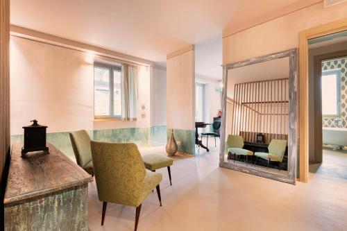 a living room with a mirror and a table and chairs at ASILO in BAROLO in Barolo