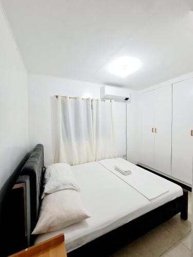 a bedroom with a bed with a white curtain at Calapan Transient Maple L82 in Calapan