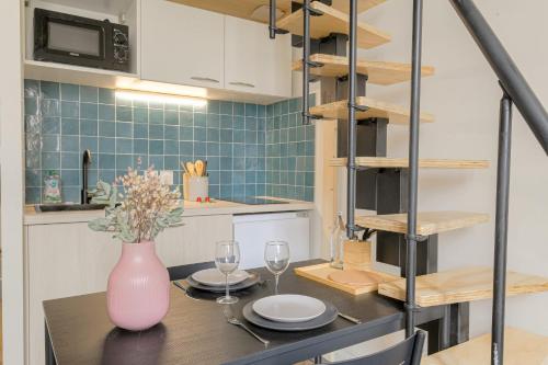 une cuisine avec une table, des verres et un vase dans l'établissement Atypique et Cosy Hôtel de Ville et quais du Rhône, à Lyon